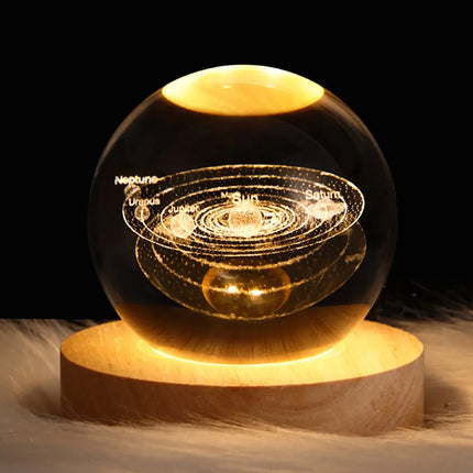 Glowing solar system 3D crystal sphere with wooden base, featuring etched planets and warm LED lighting for desk decor
