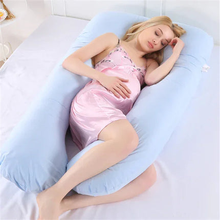 Light blue U-shaped pregnancy pillow supporting pregnant woman in pink pajamas, promoting comfort and sleep.