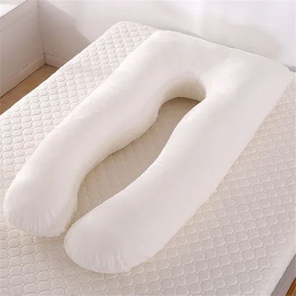 White U-shaped pregnancy pillow for side sleeping, supportive design on quilted mattress