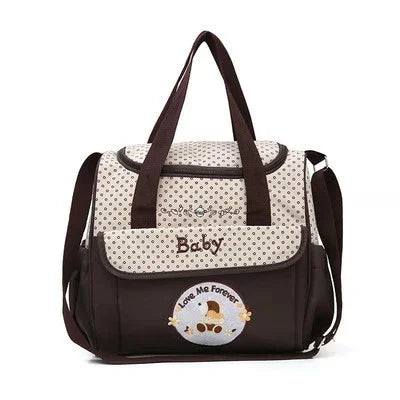 Brown and cream polka dot baby diaper bag with 'Baby' text and 'Love Me Forever' patch, dual handles, shoulder strap