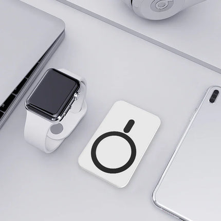 White wireless charging pad with black circular design, charging smartwatch and phone