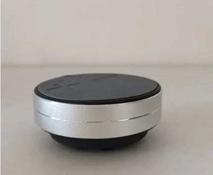 Compact black and silver Bluetooth speaker with touch controls, portable wireless audio device