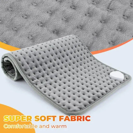 Gray heated massage pad with soft fabric, dotted texture, and control button for warmth and comfort
