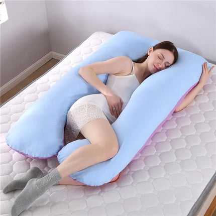Light blue U-shaped pregnancy pillow with pink trim, supporting side sleeper for comfort and alignment