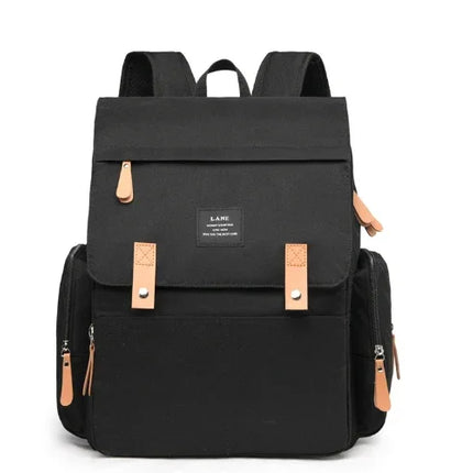 Black canvas backpack with tan leather accents, front flap, and side pockets for school or travel